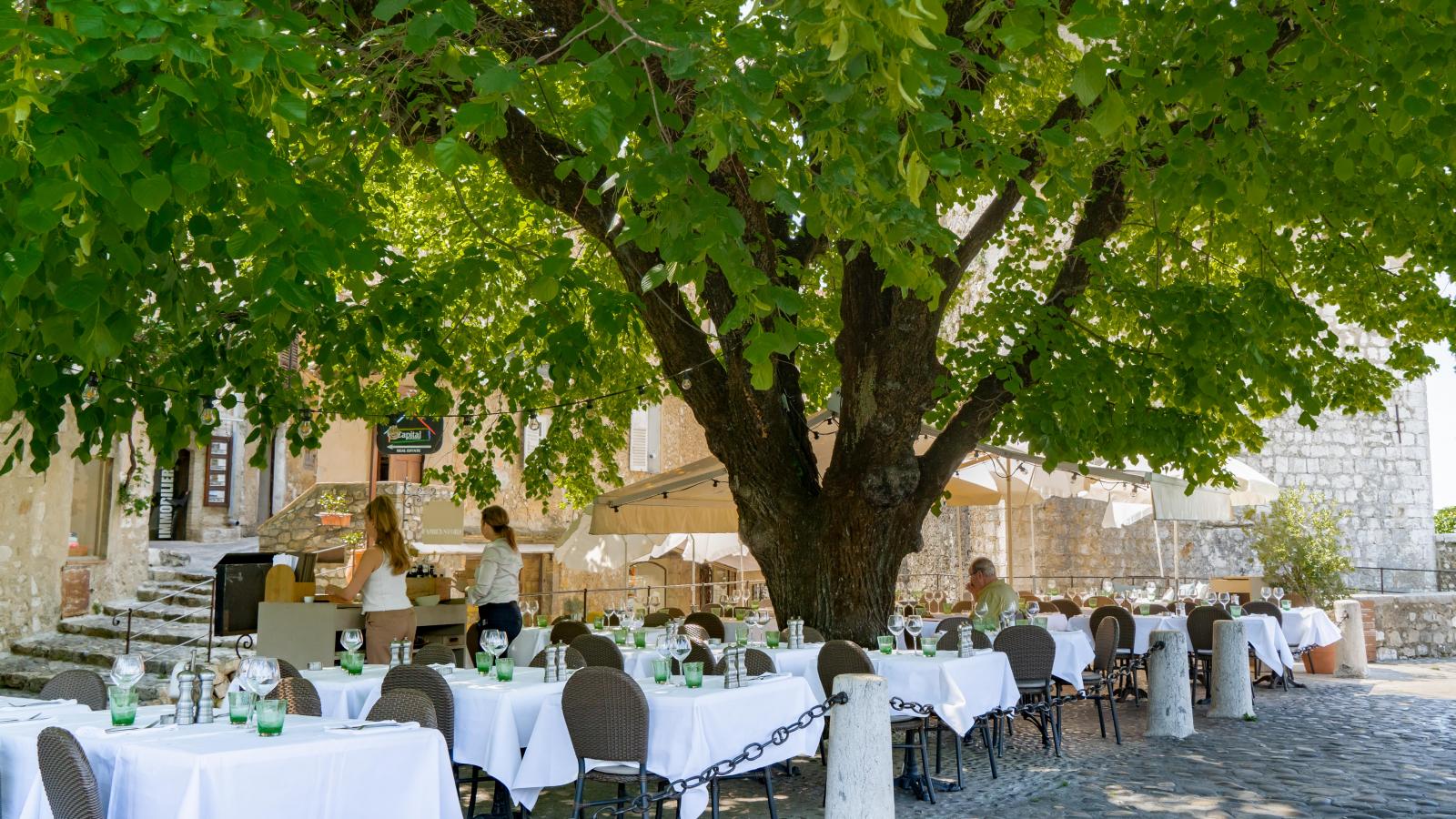 La terrasse du Tilleul sous les feuilles, dressee de nappes blanches